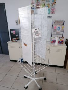 Espositore girevole con 2 facciate di pannelli forati, 2 con tasche e cesta contenitiva.
